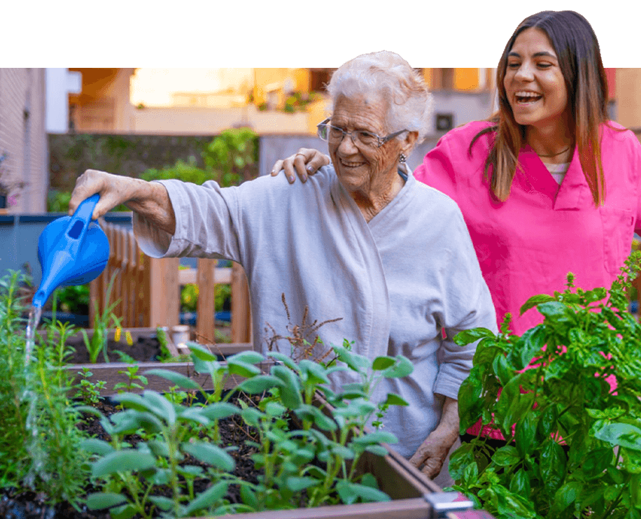 Senior woman watering plants outside.